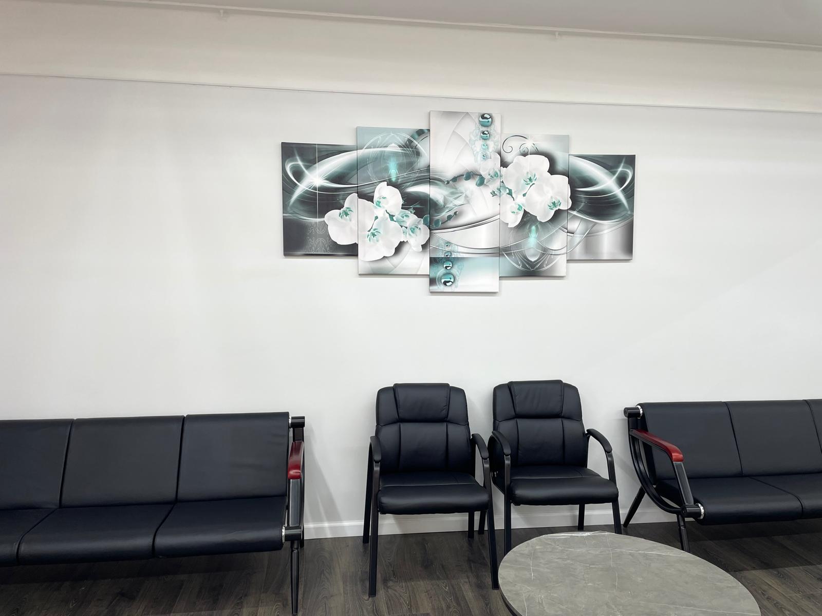 Waiting area with orchid wall art and leather seating